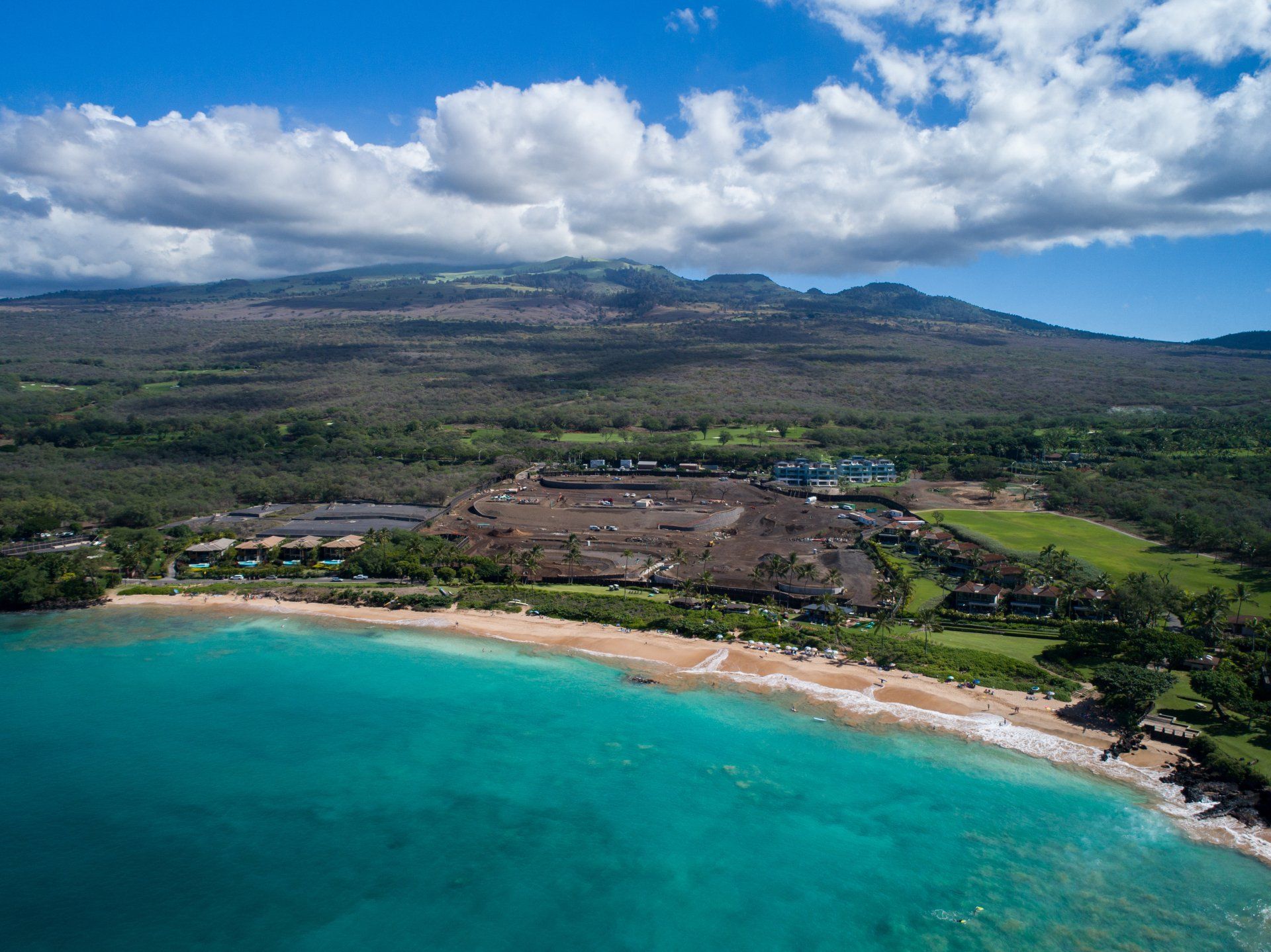 An aerial view of a beach with mountains in the background