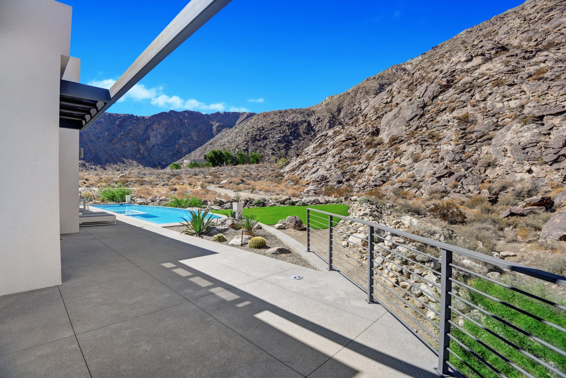 A patio with a view of mountains and a swimming pool