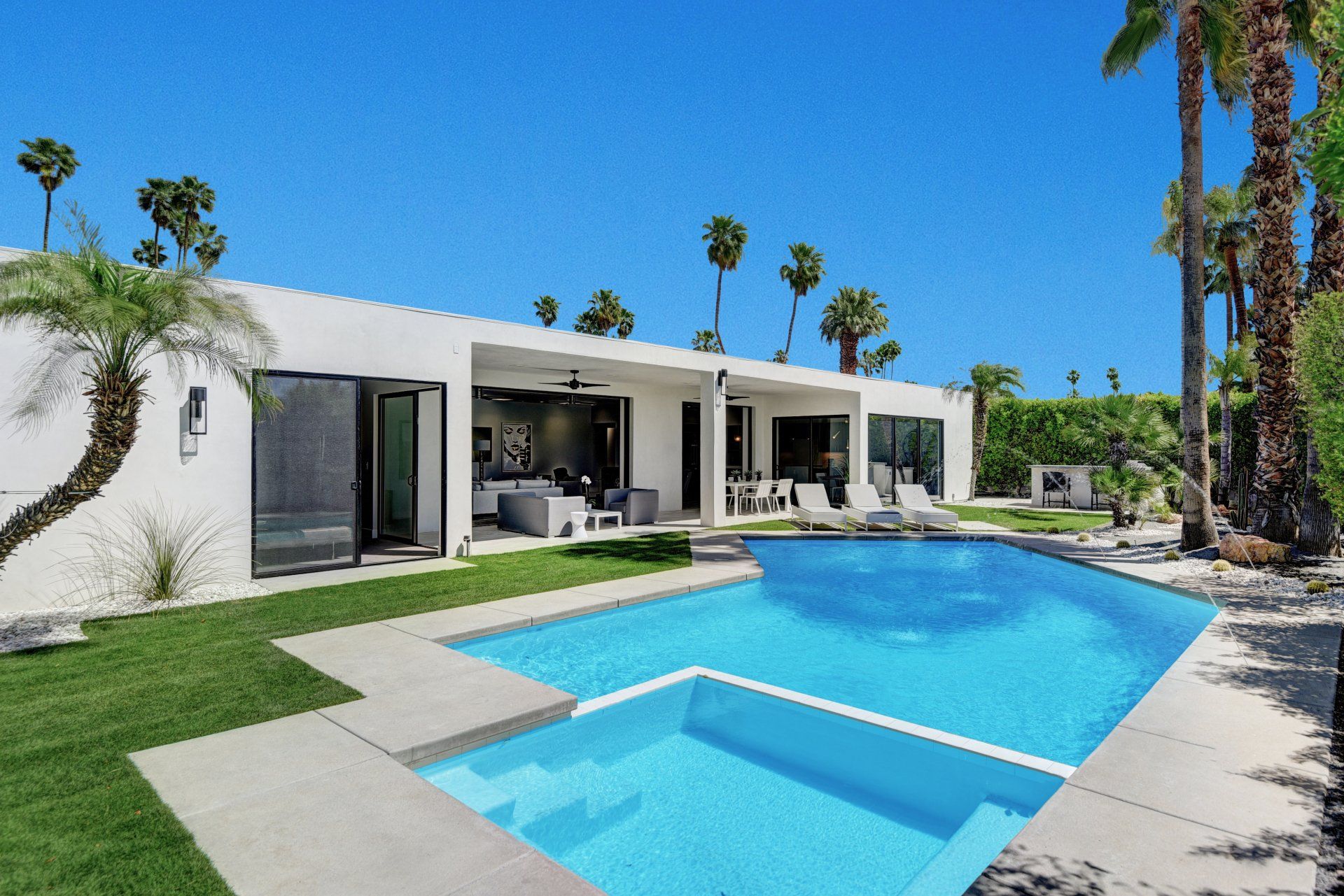 A white house with a large swimming pool in front of it