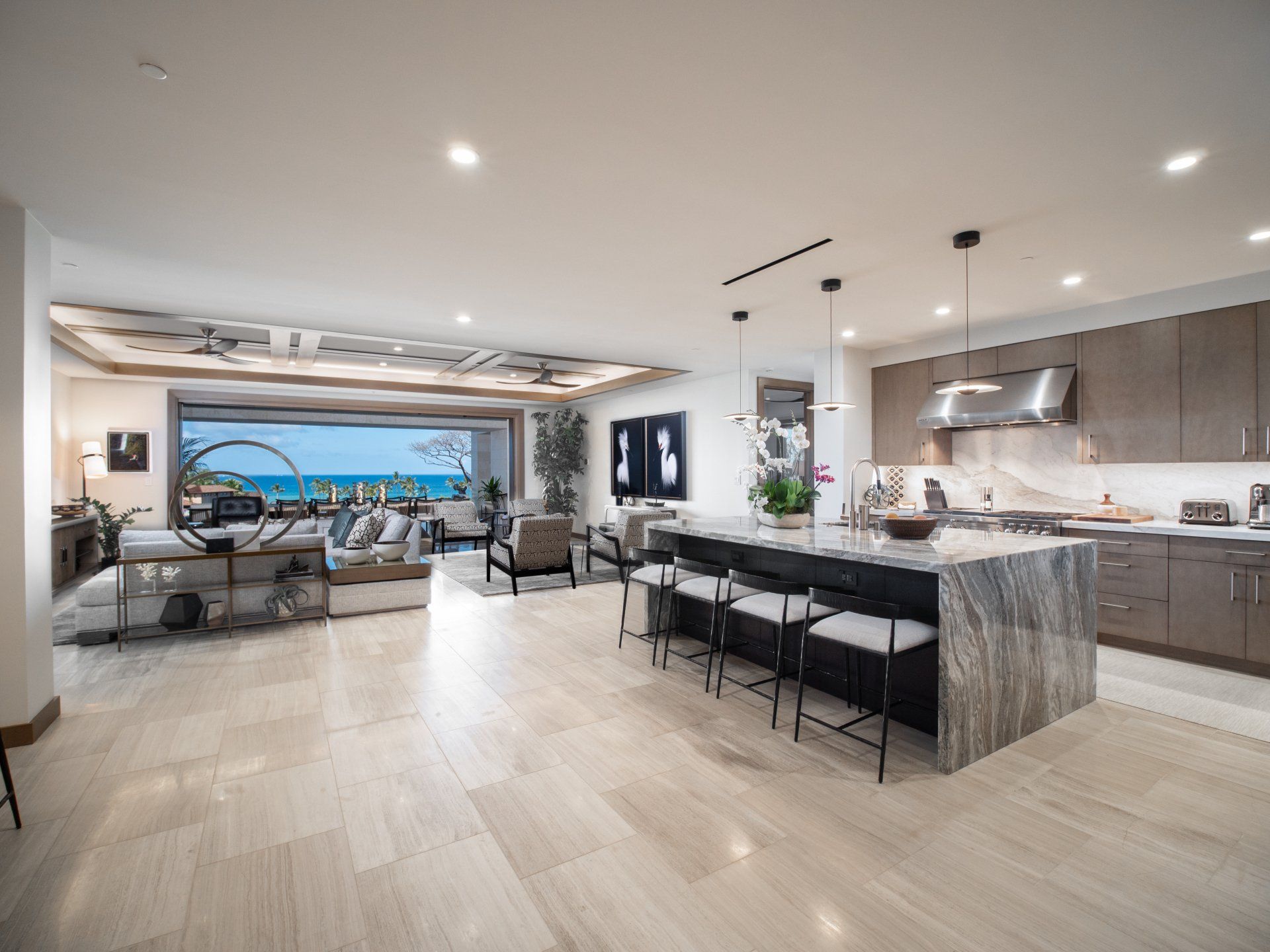 A large living room and kitchen with a large island in the middle of the room.