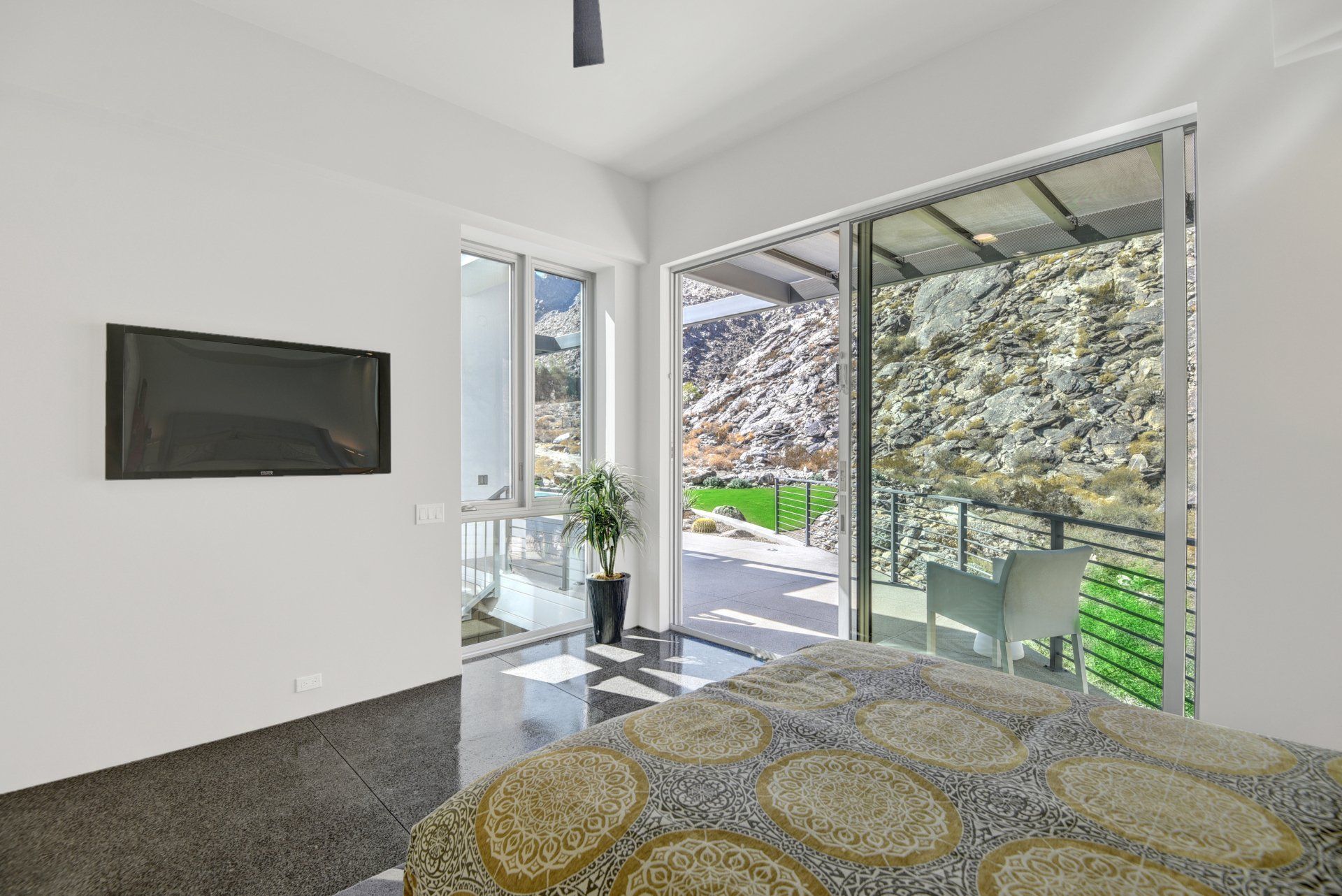 A bedroom with a large bed and a flat screen tv on the wall.