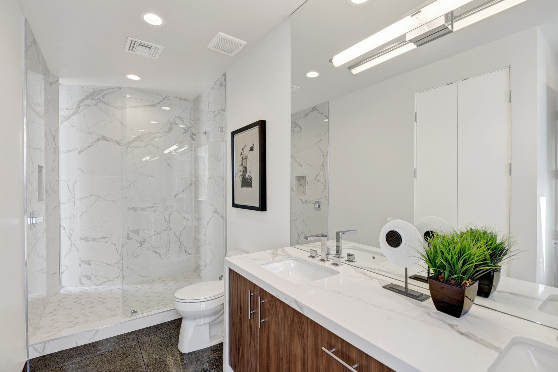 A bathroom with a toilet , sink , and mirror.