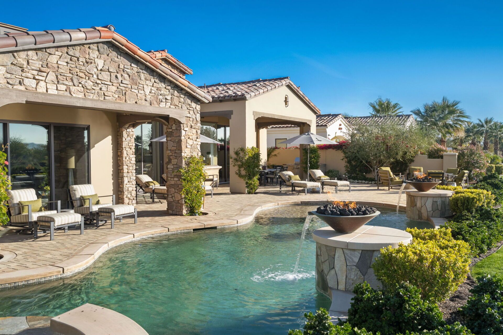 A large house with a swimming pool in front of it.