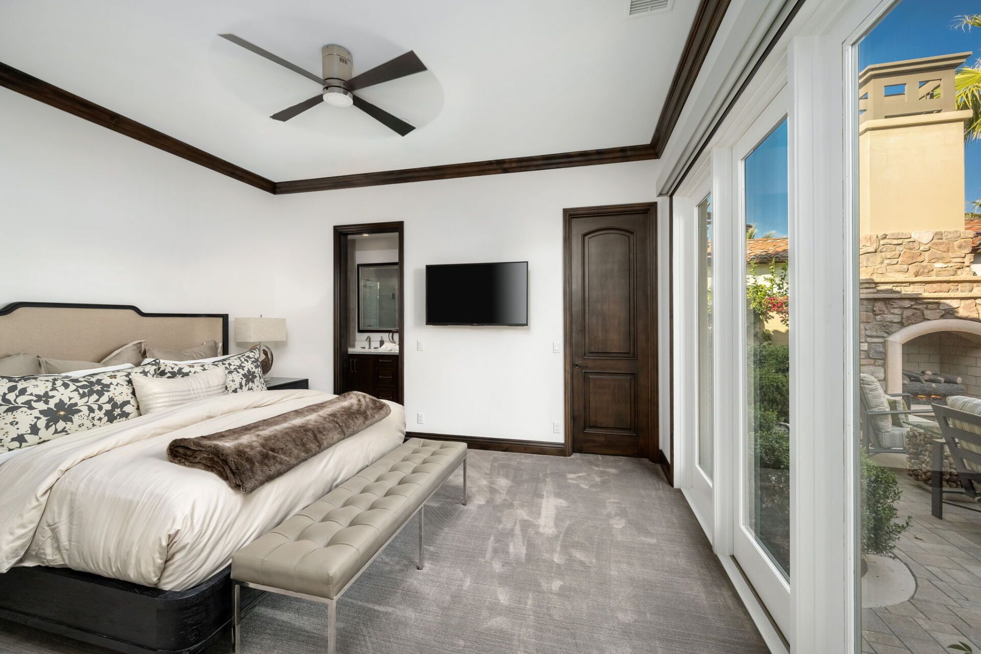 A bedroom with a large bed and a flat screen tv on the wall.