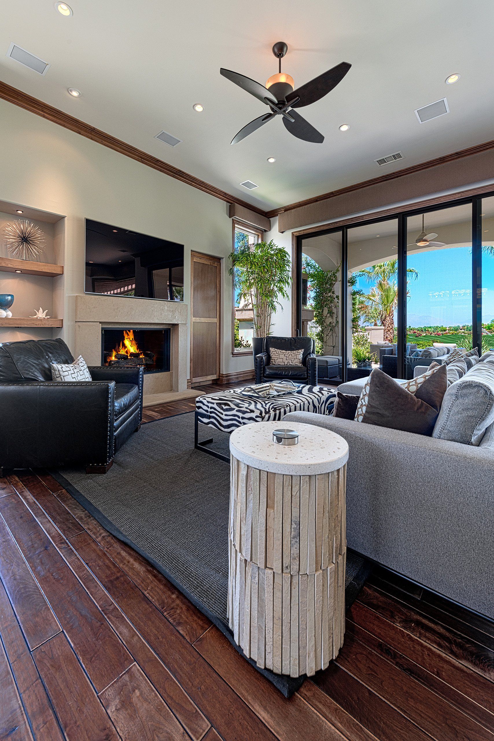 A living room filled with furniture and a fireplace with a ceiling fan.