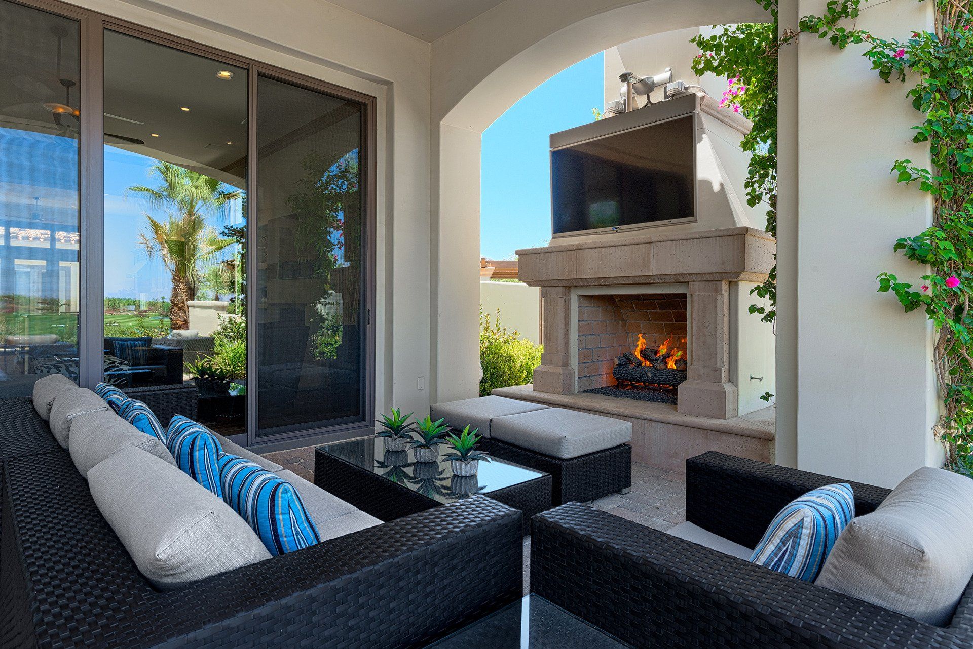 A patio with a fireplace and a couch and chairs