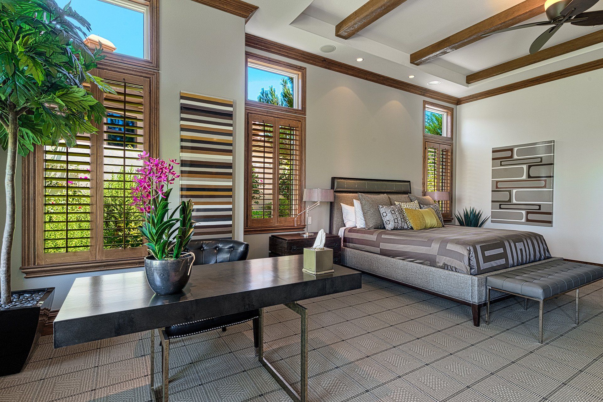A bedroom with a large bed and a desk.