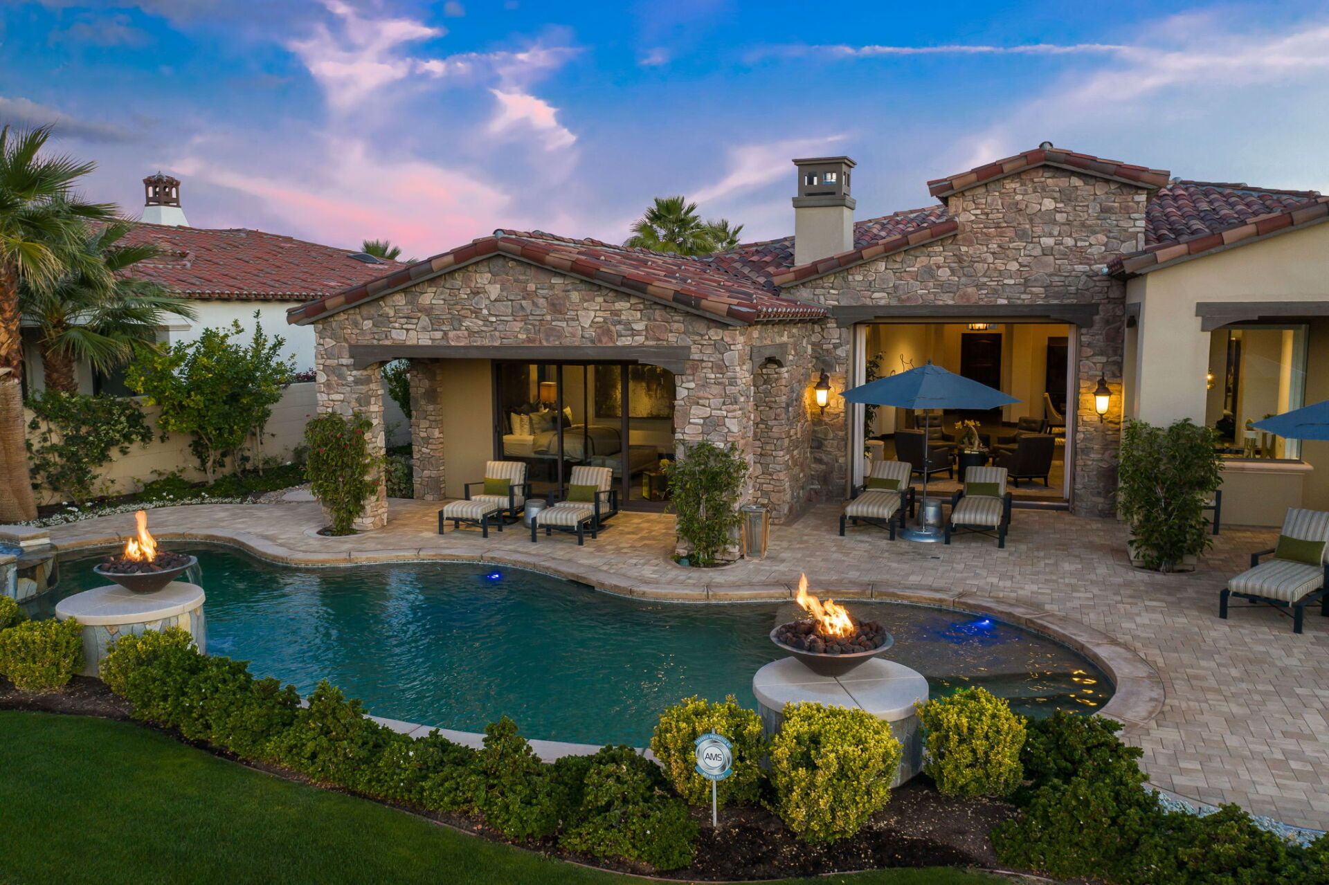 A large house with a large swimming pool in front of it.