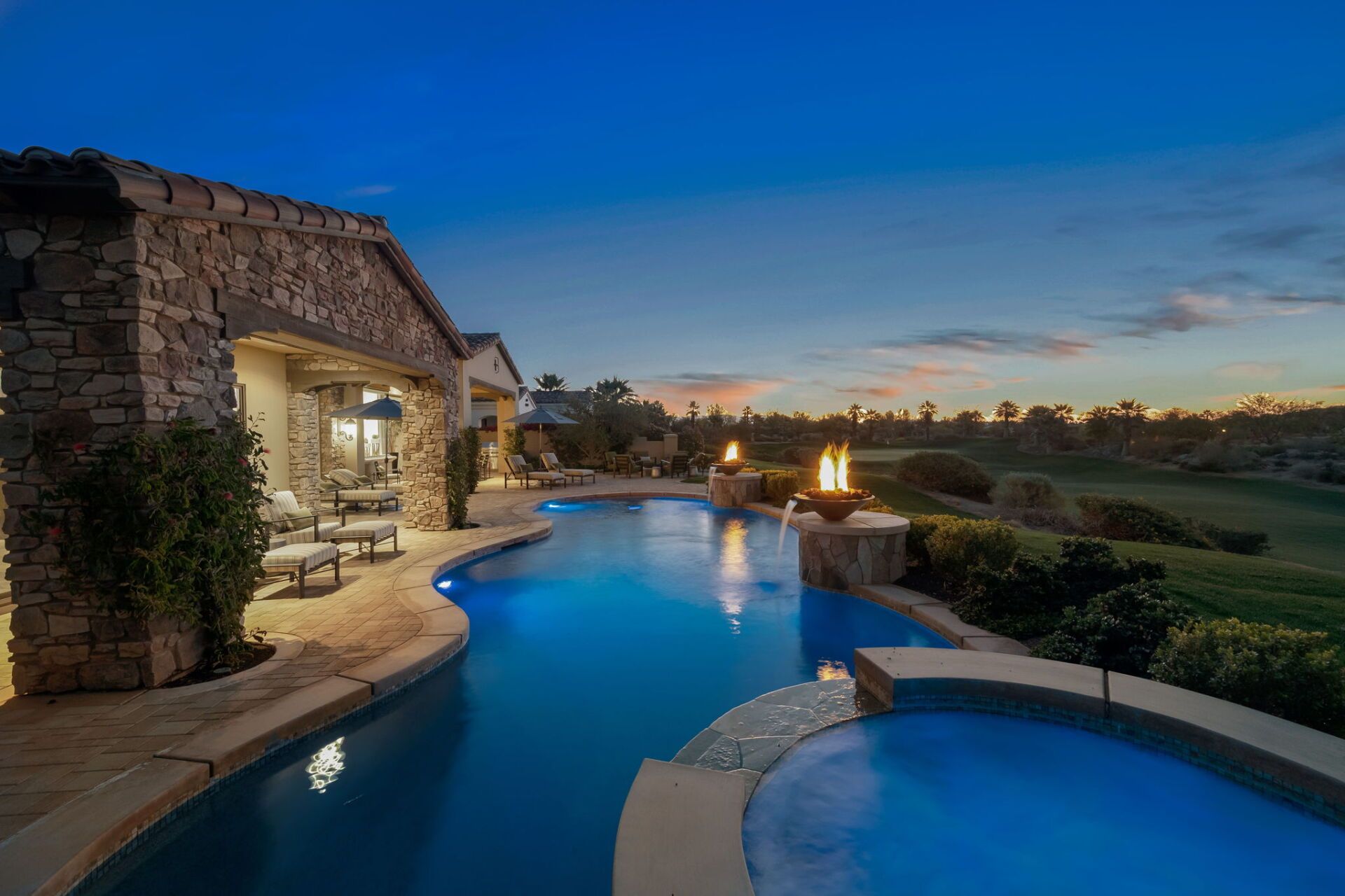There is a large swimming pool in the backyard of a house.