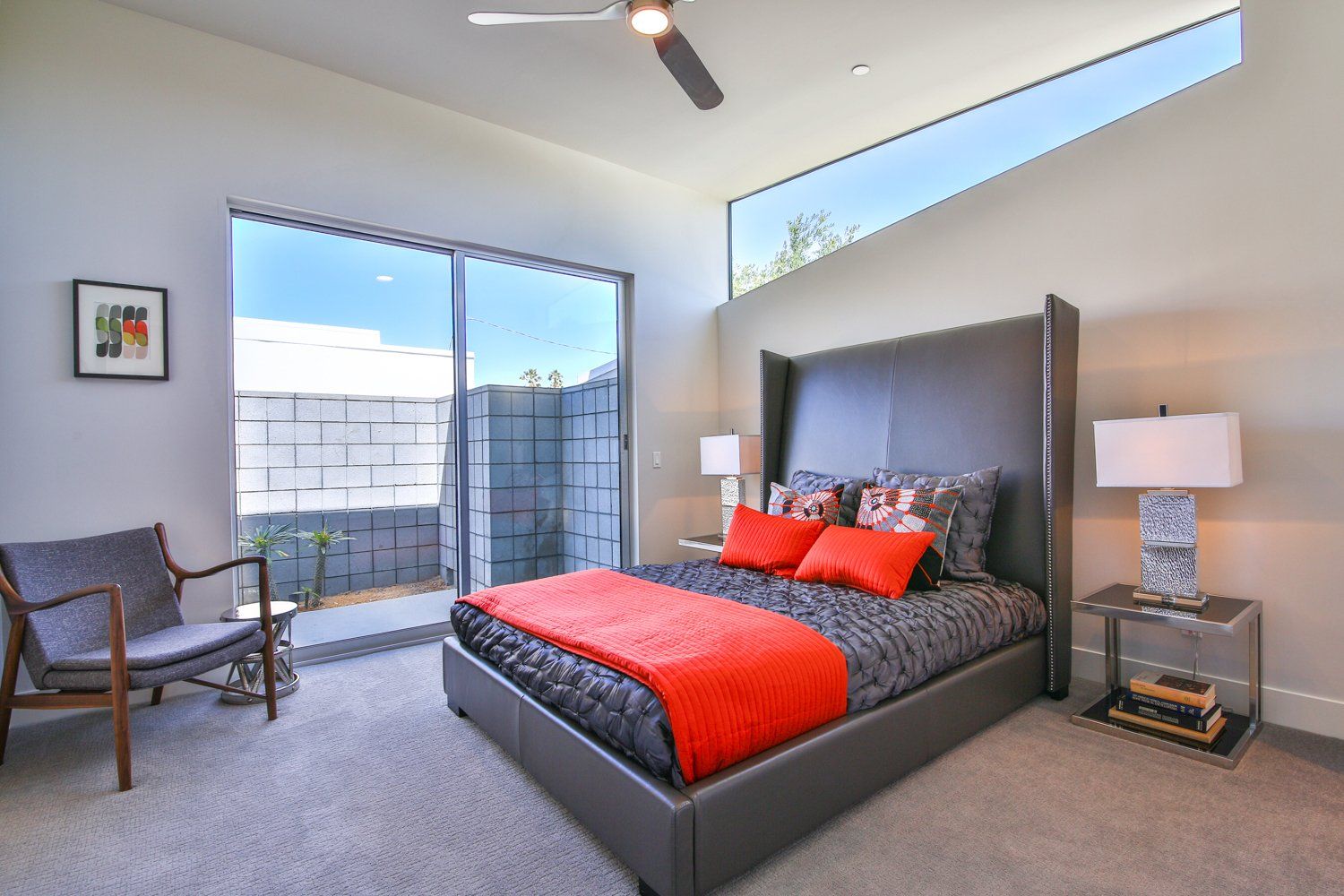 A bedroom with a large bed and a chair