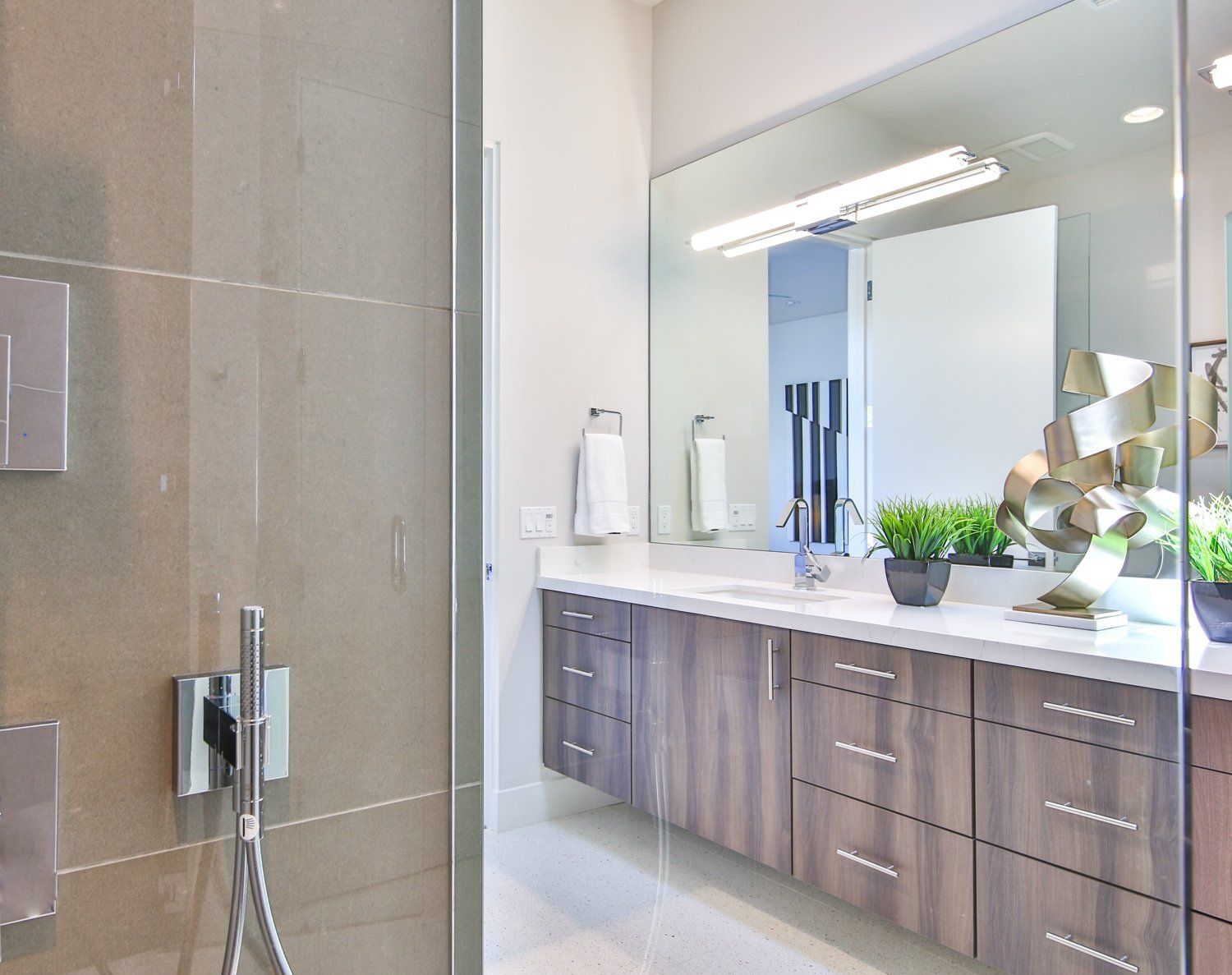 A bathroom with a large mirror and a walk in shower