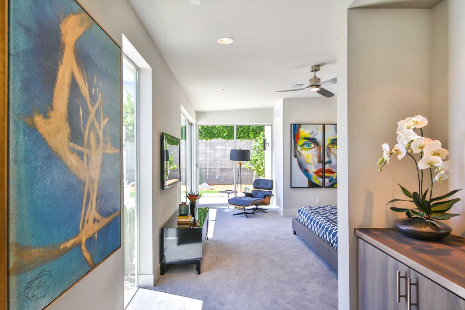 A hallway leading to a bedroom with a painting on the wall.