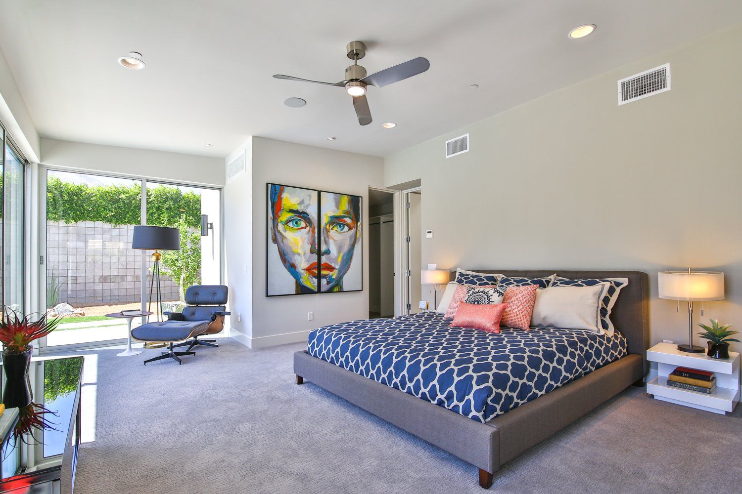 A bedroom with a large bed and a painting on the wall