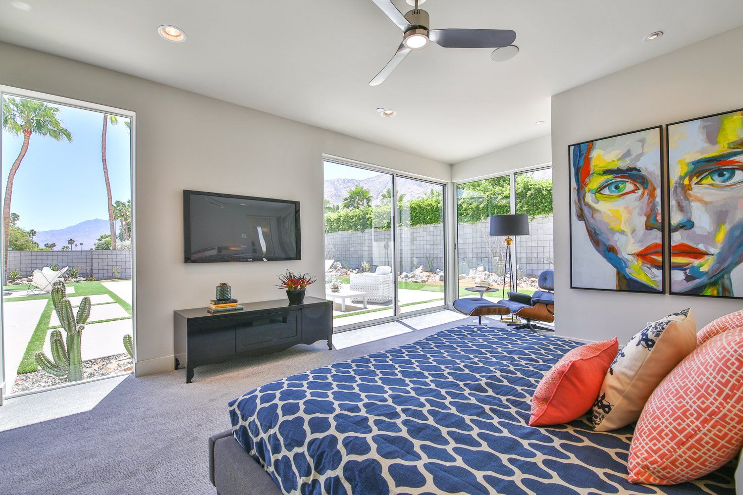 A bedroom with a large bed and a television on the wall
