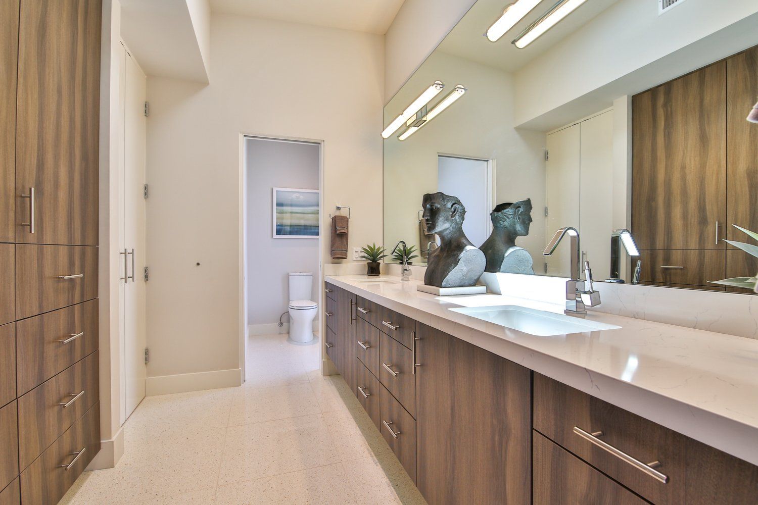 A bathroom with two sinks and a large mirror.