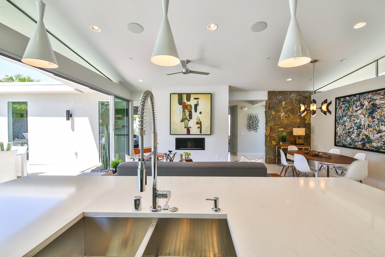 A kitchen with a sink and a dining room in the background.