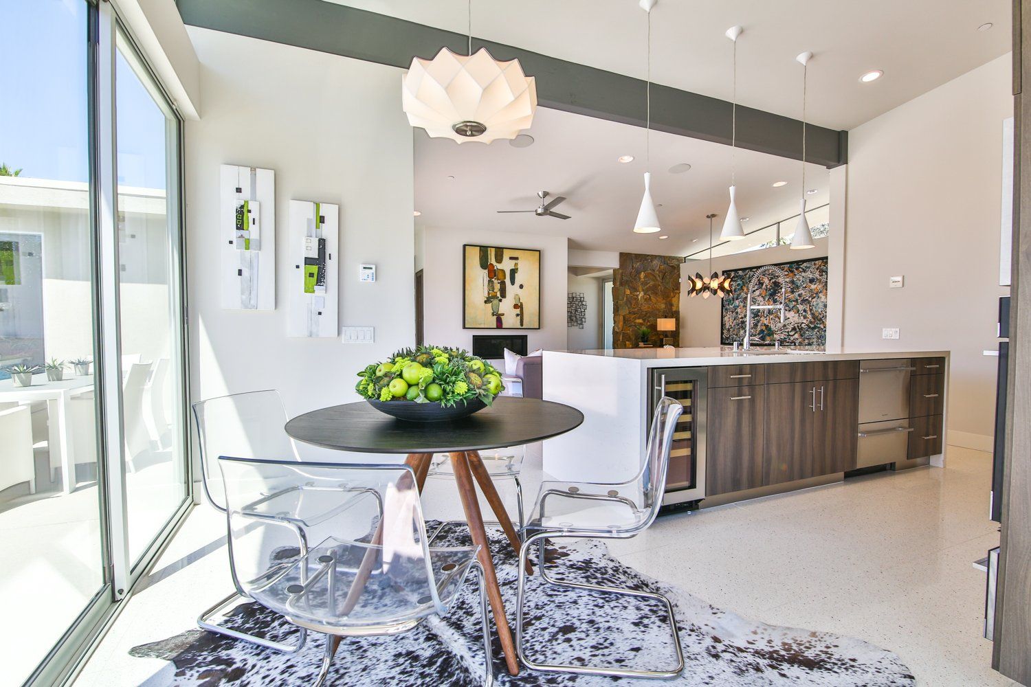 A dining room with a table and chairs and a large window.