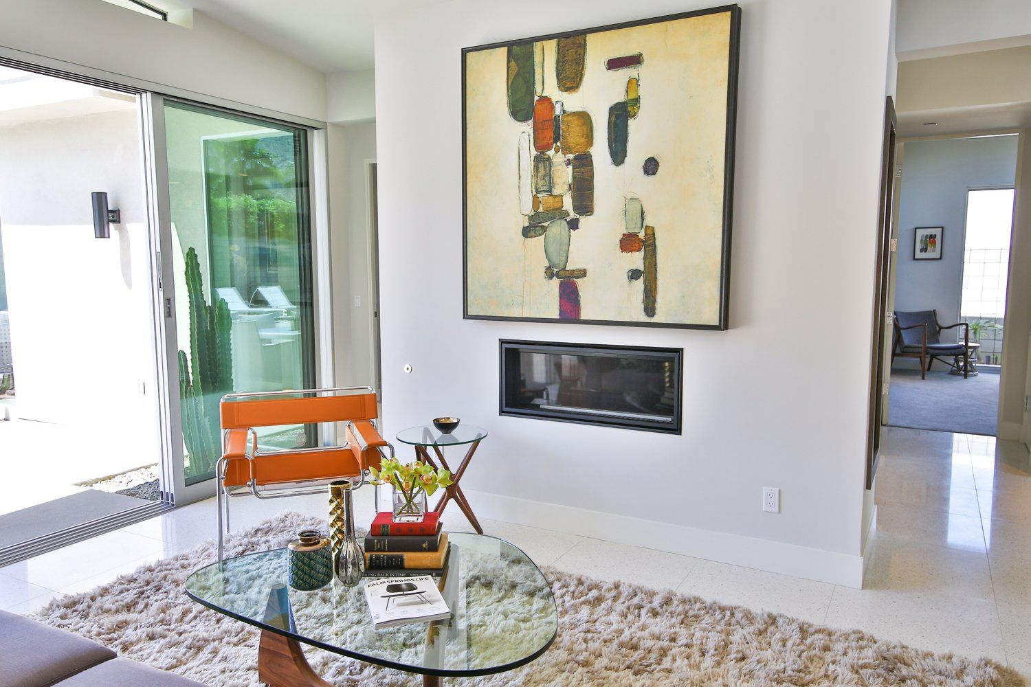 A living room with a fireplace and a painting on the wall