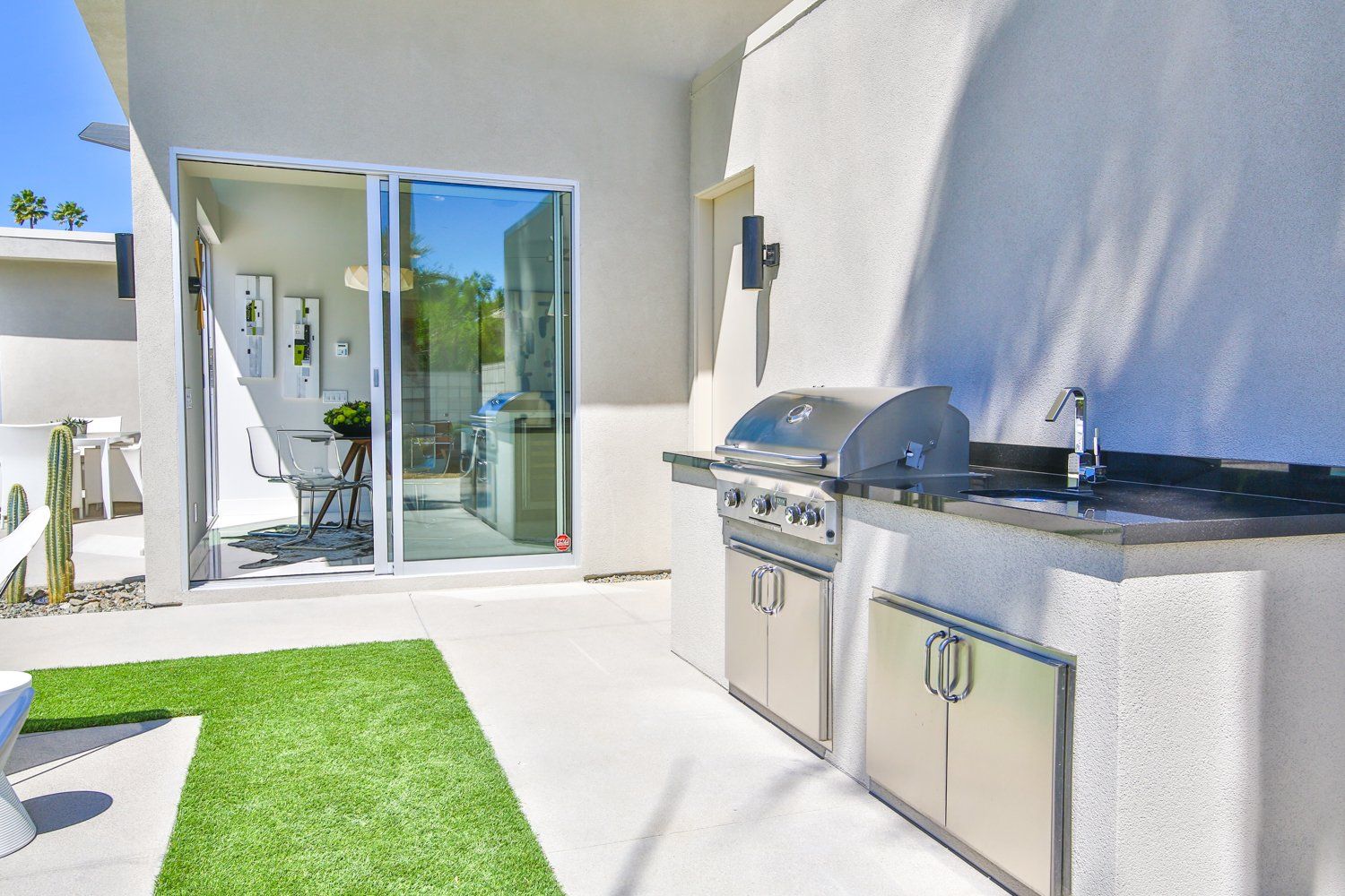 A patio with a grill and a sliding glass door