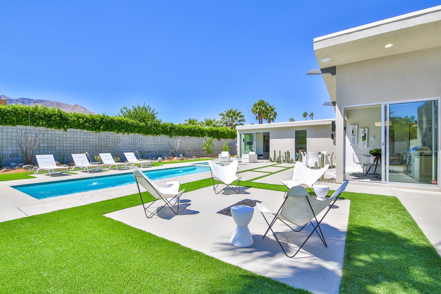 There is a large swimming pool in the backyard of a house.