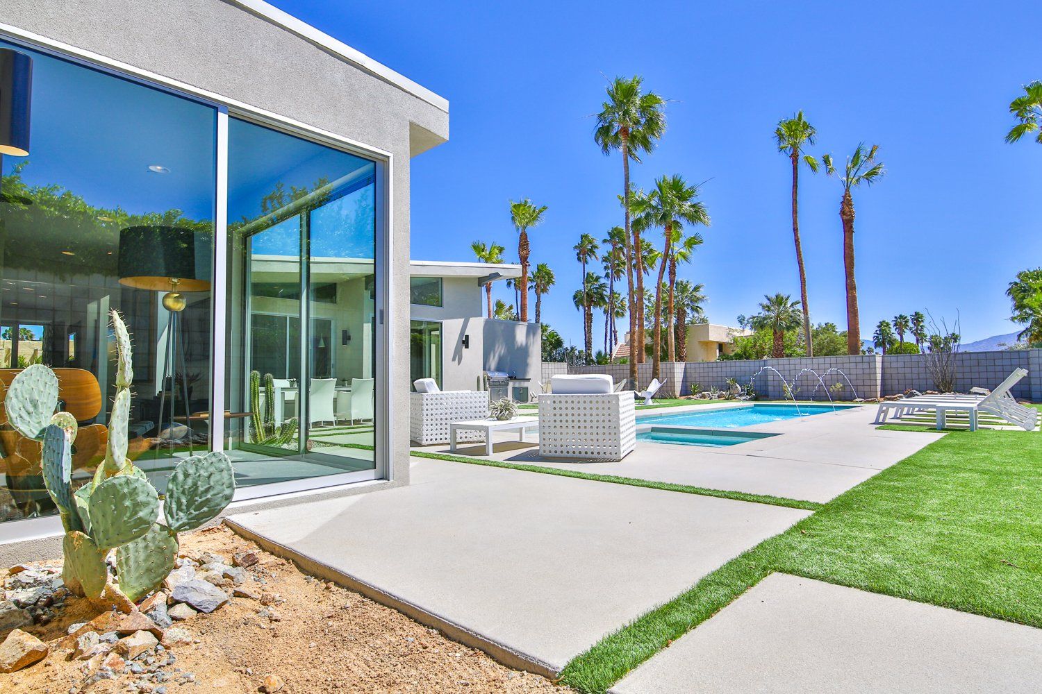 A large white house with a swimming pool and palm trees