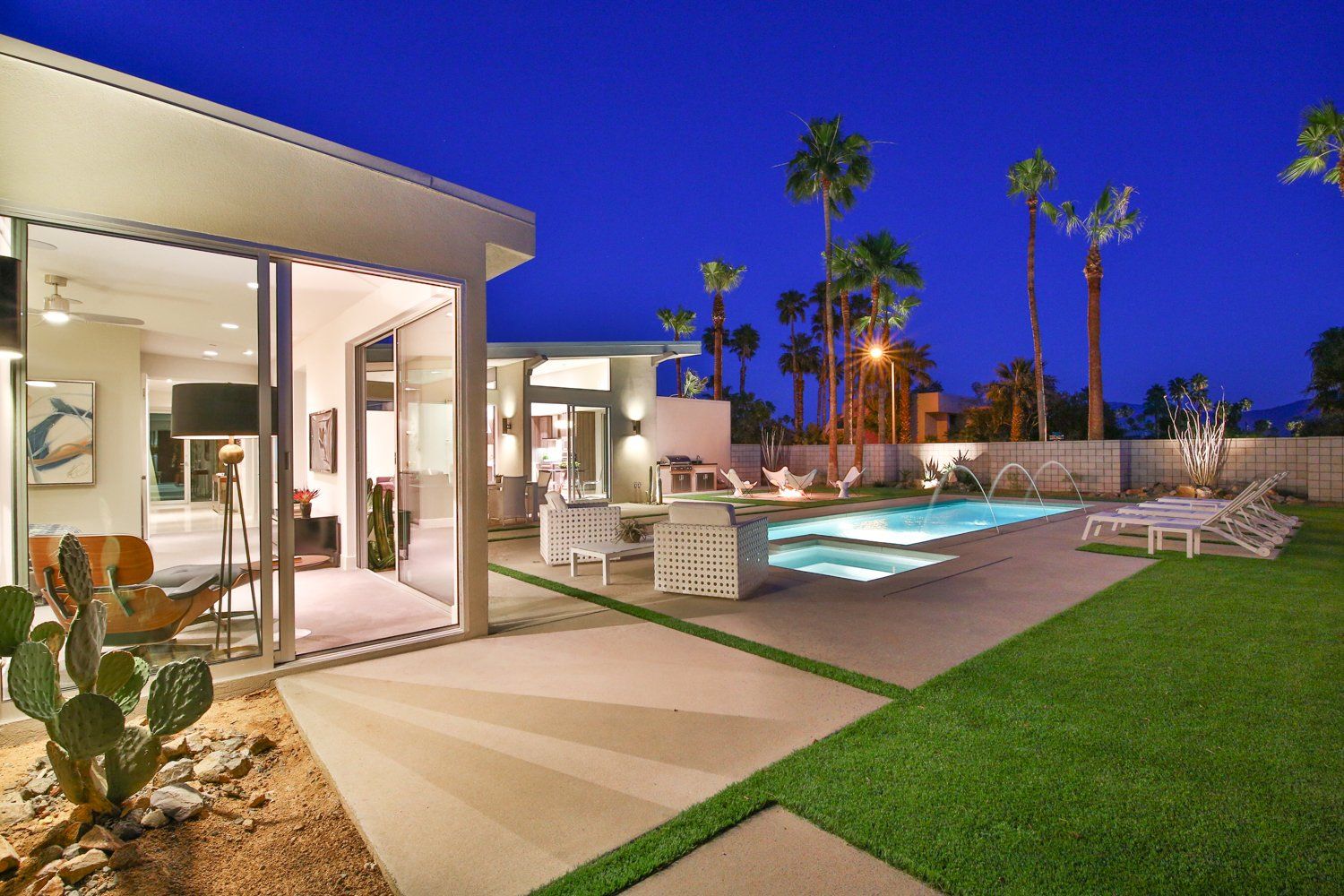 A house with a swimming pool in the backyard at night