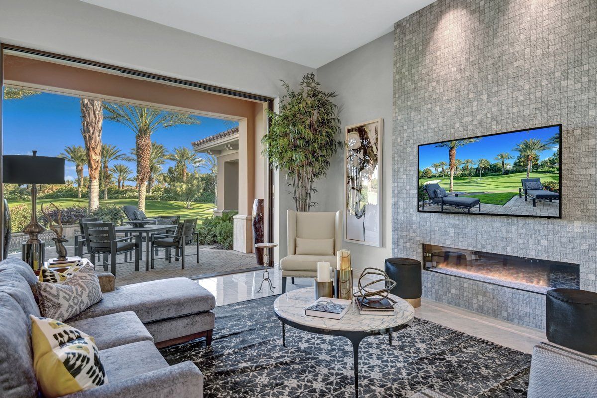 A living room with a fireplace and a flat screen tv on the wall.