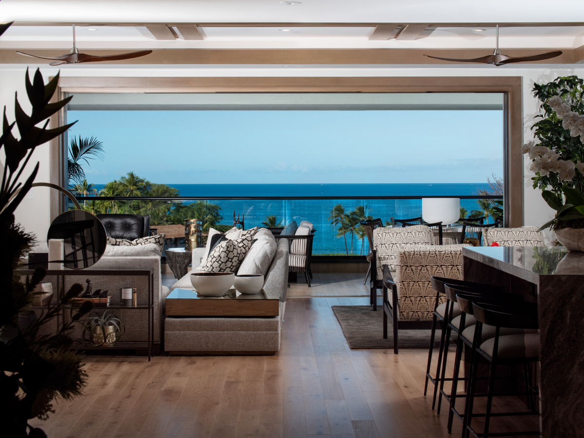 A living room with a view of the ocean and a balcony.