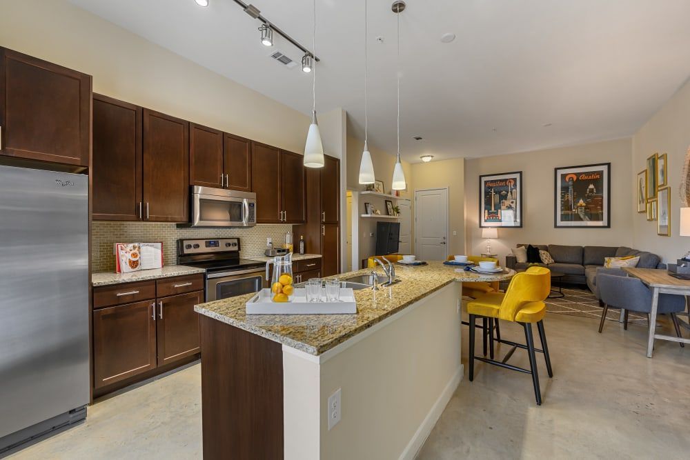 Apartment kitchen with stainless steel appliances and granite counter tops at The 704 in South Lamar Austin, TX.