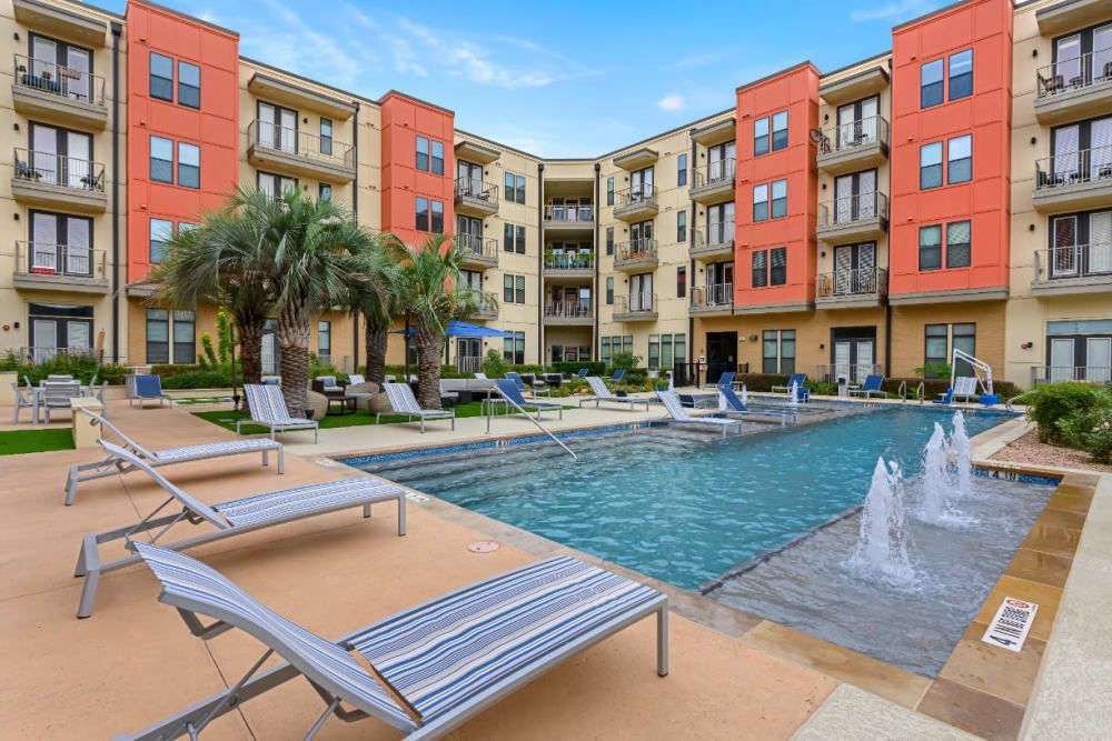 Apartment buildings with an outdoor swimming pool in front of it at The 704 in Austin TX.