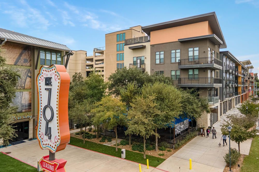 An aerial view of the apartment building with a apartment signage in front of it at The 704 in South Lamar Austin, TX.
