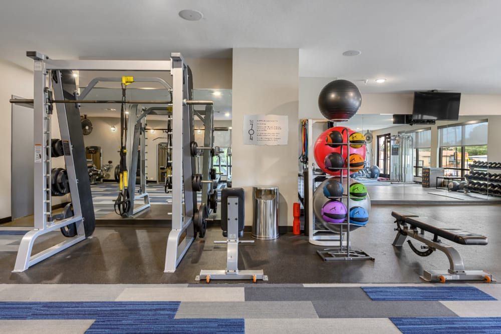 An apartment fitness center with a lot of equipment and a large mirror at The 704 in Austin TX.