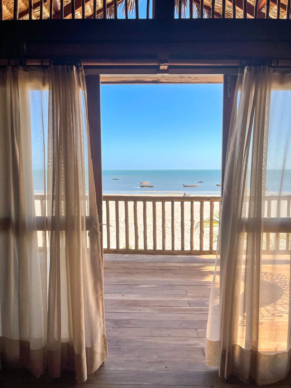 vista para o mar a partir de uma varanda com cortinas abertas