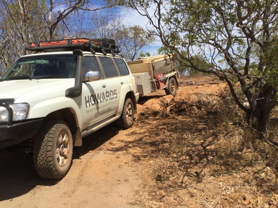 A White Suv is Parked on a Dirt Road With a Trailer Attached to It — Howards Professional Driving School In Gordonvale, QLD