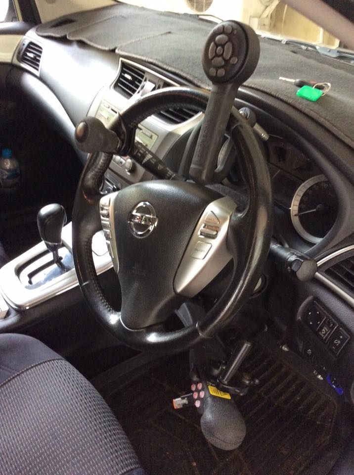 A Steering Wheel With a Remote Control Attached to It — Howards Professional Driving School In Babinda, QLD