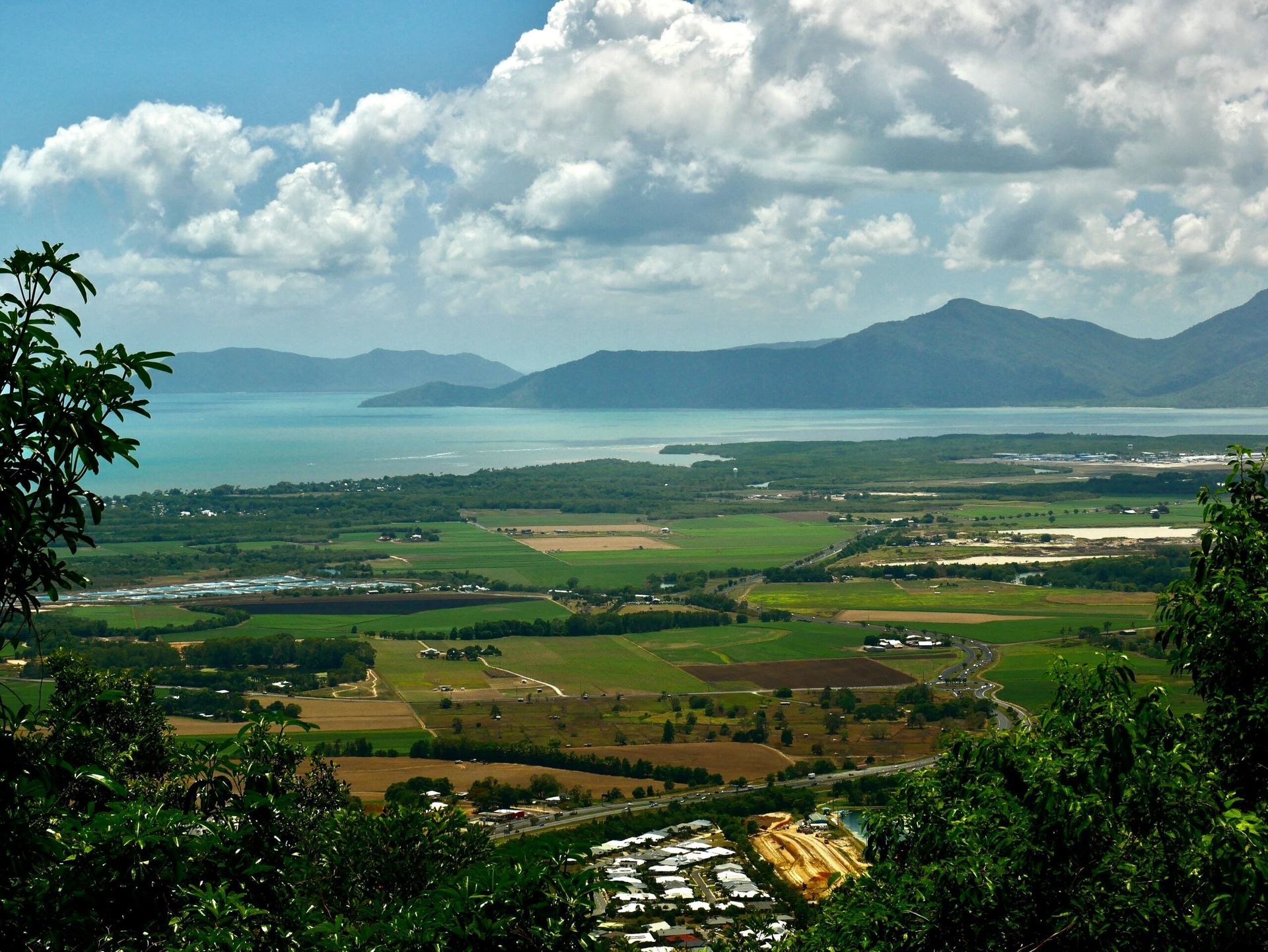 A View of a Large Body of Water With Mountains in the Background — Howards Professional Driving School In Cairns, QLD