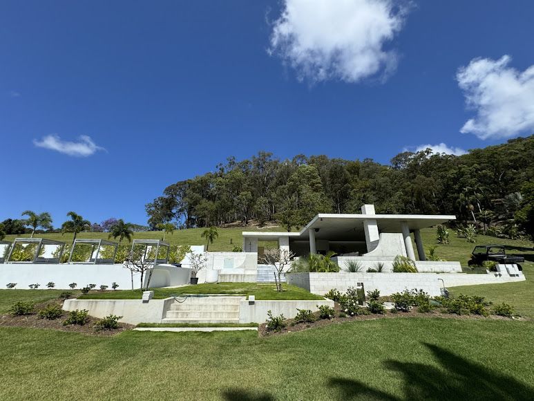A Large White House is Sitting on Top of a Hill Surrounded by Trees — Construction 33 in Maroochydore, QLD