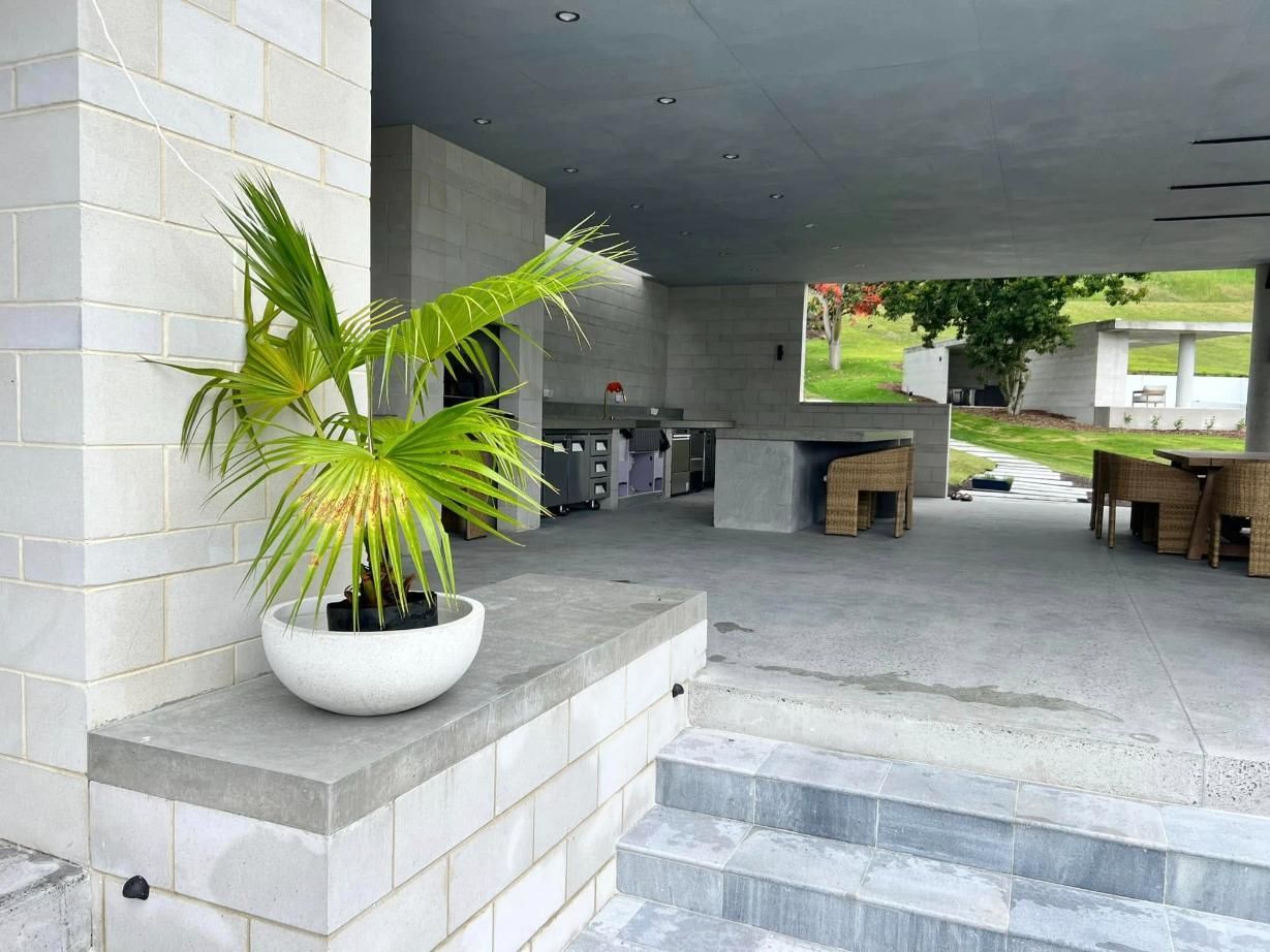 A Potted Plant is Sitting on a Ledge Next to Stairs — Construction 33 in Buderim, QLD