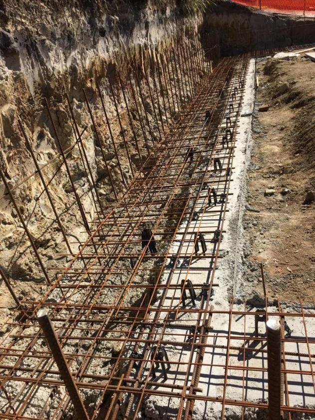 Fence is Being Built in the Dirt Next to a Rock Wall — Construction 33 Concreting in Moreton Bay, QLD