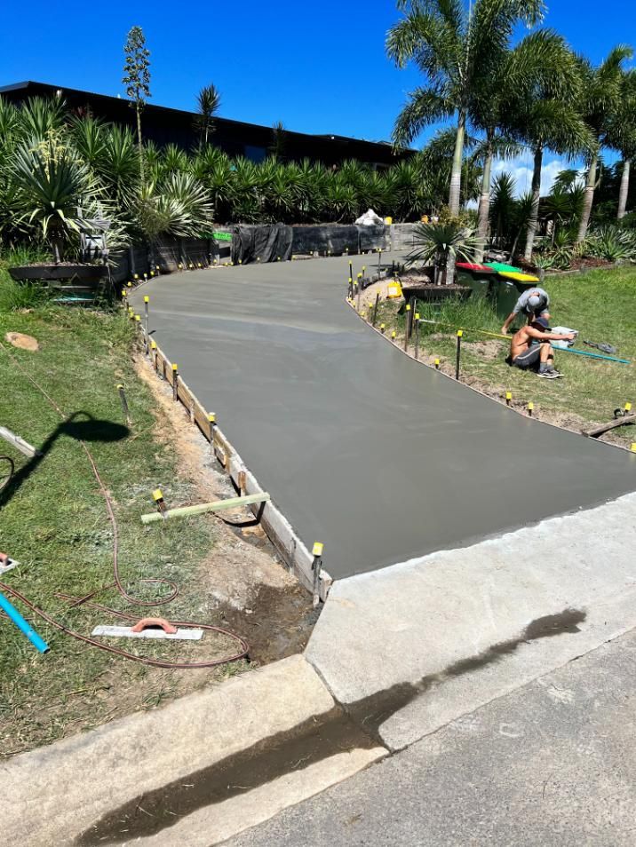 Man is Sitting on the Side of a Concrete Driveway — Construction 33 in Maroochydore, QLD