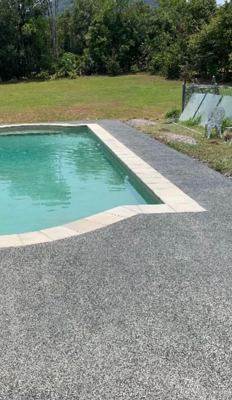 A Large Swimming Pool Surrounded by Grass and Trees in a Backyard — Construction 33 in Maroochydore, QLD