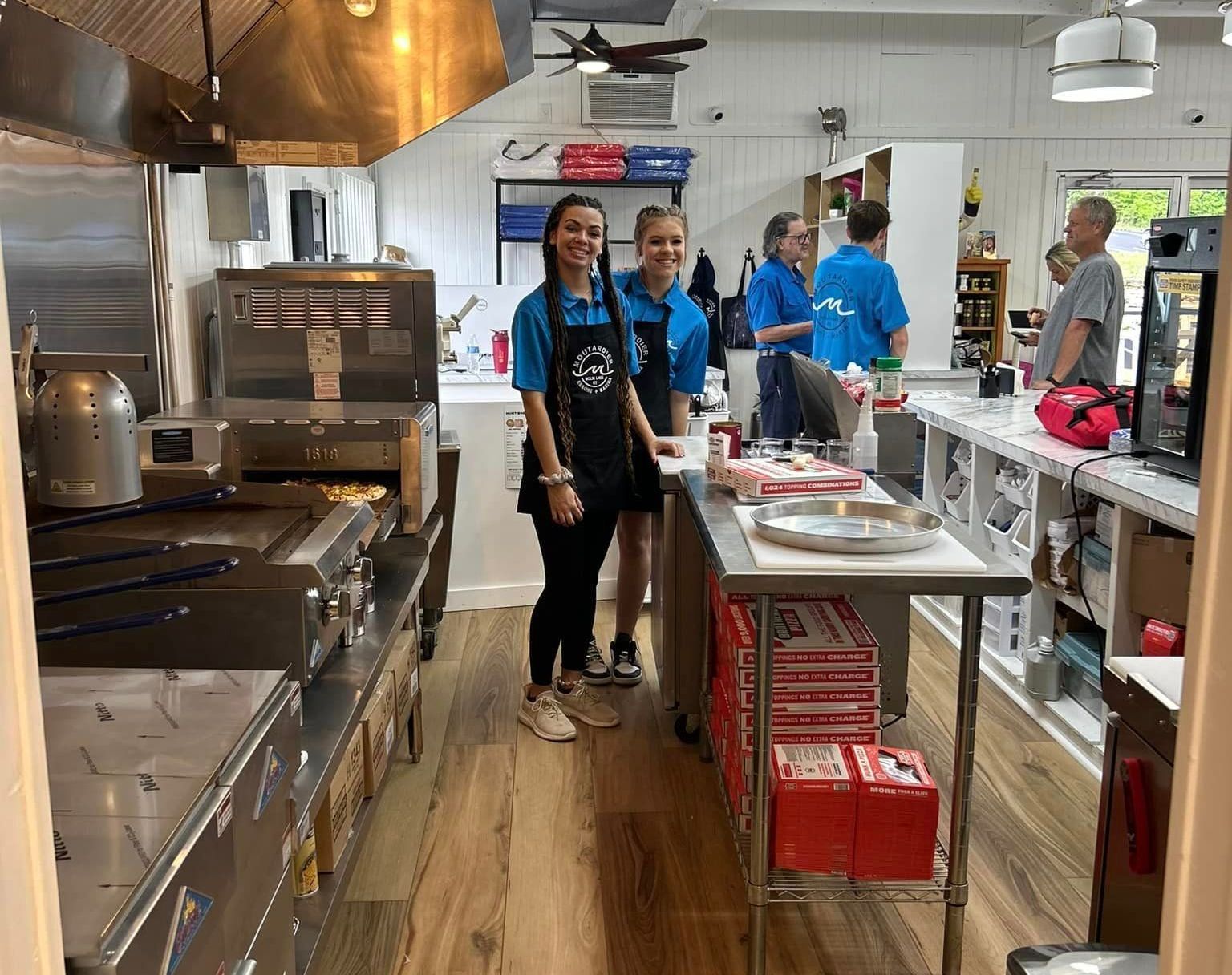 A group of people are standing in a kitchen.