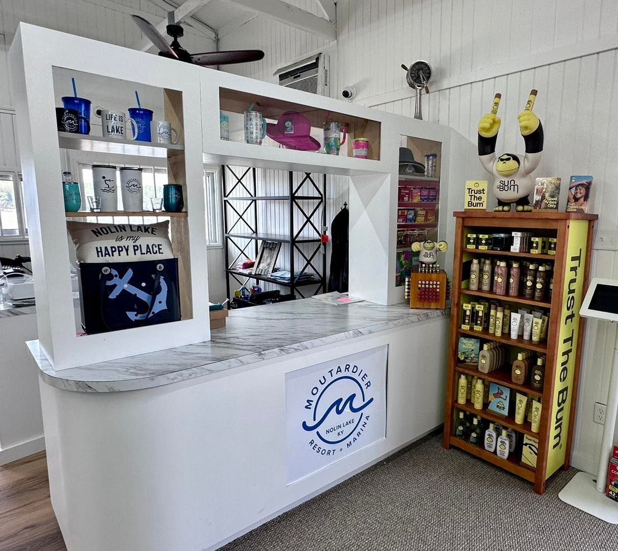 A large white counter in a room with a shelf full of items.
