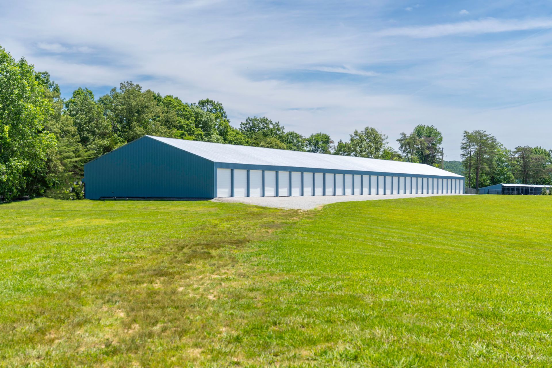 A large building is sitting in the middle of a lush green field.