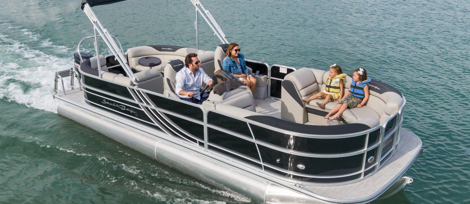 A group of people are sitting on a pontoon boat in the water.