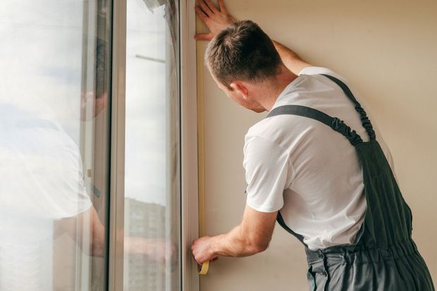 Edificio residenziale a più piani con balconi, dettagli blu e cielo azzurro.