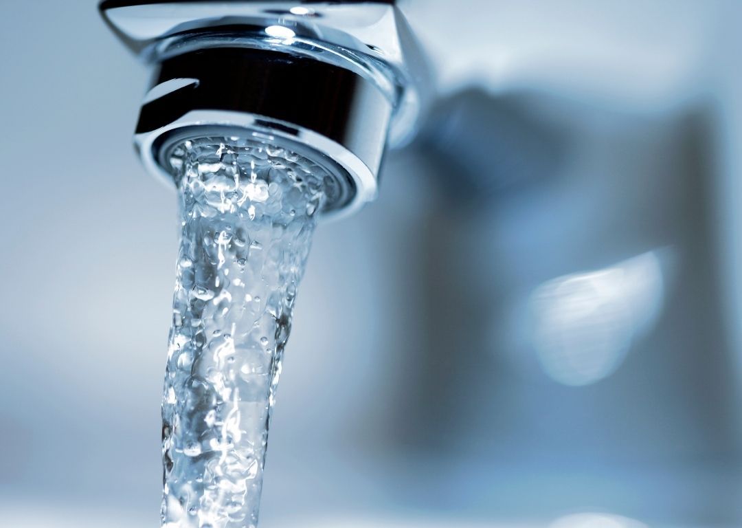 Water is pouring from a faucet into a sink.