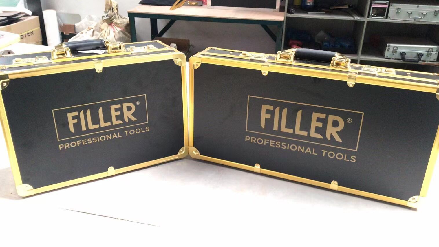 Dos cajas de herramientas negras con detalles dorados, etiquetadas