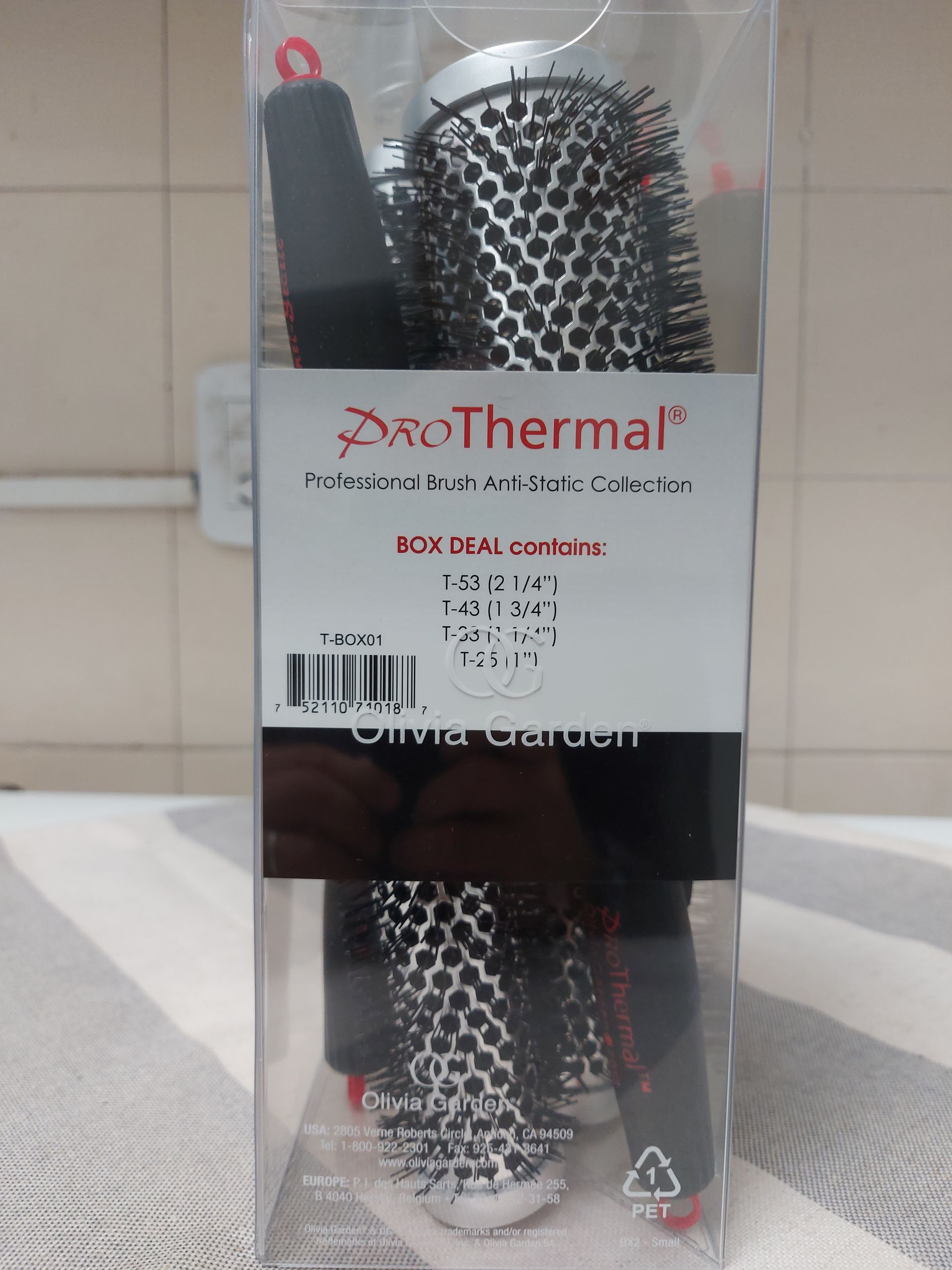 Cepillos para peinar el cabello en un paquete de plástico transparente con detalles en negro y rojo.