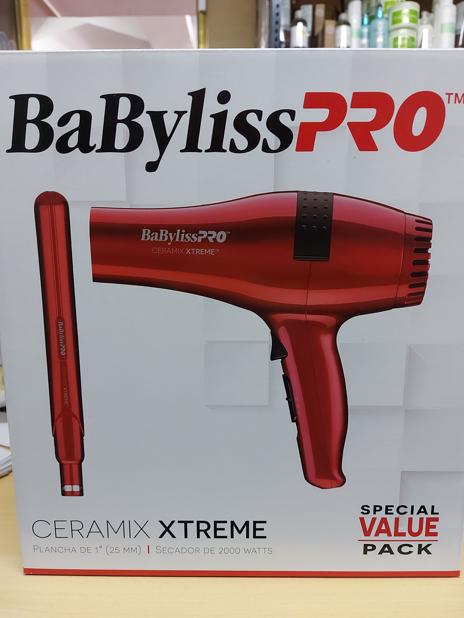 Caja con secador de pelo BaBylissPRO de color rojo y tenaza para peinar; lleva impreso